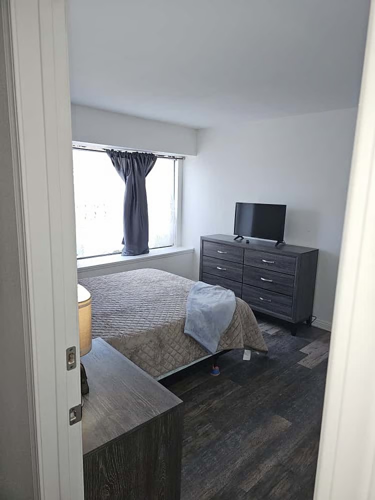 Bedroom view with dresser and smart TV
